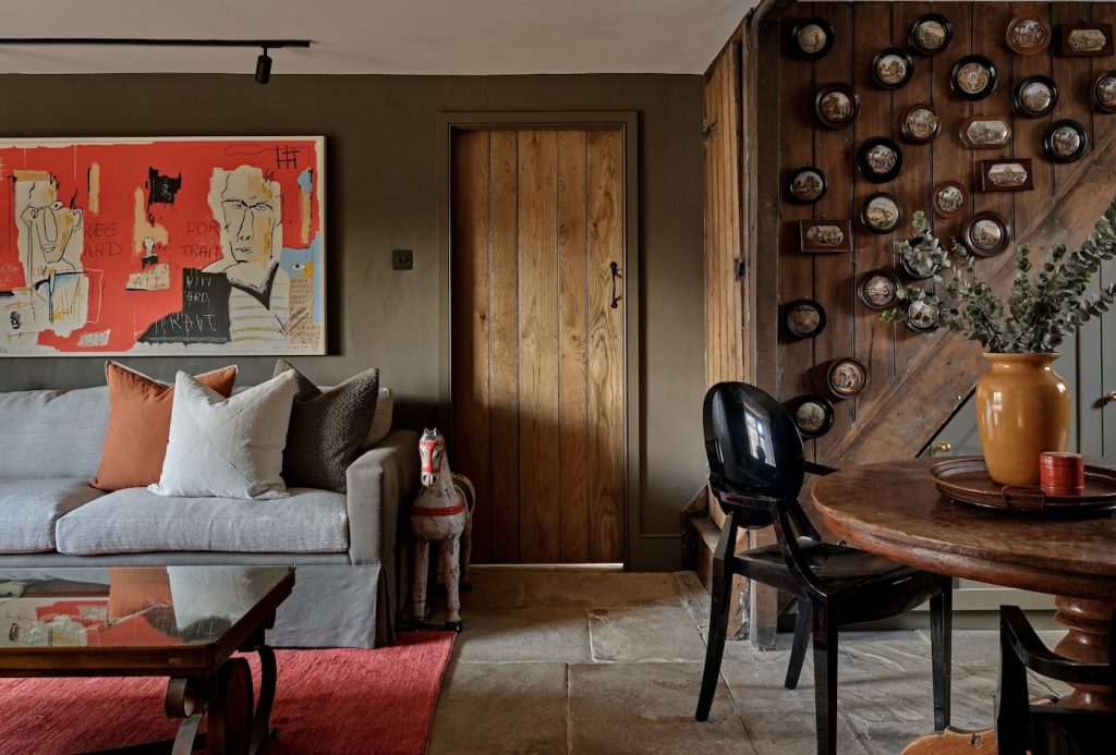 Layered Cotswold interior combining original architectural character with contemporary furniture and artwork.