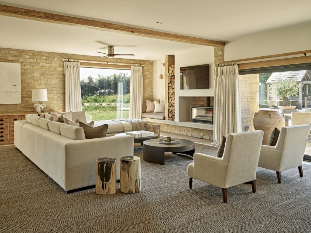Light-filled living room in a Cotswolds country home with exposed stone walls, timber beams and bespoke interior design
