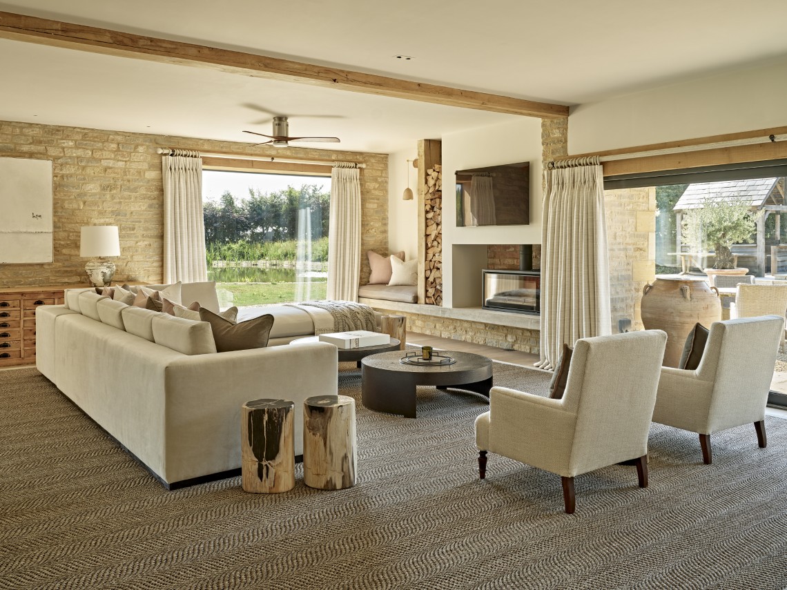 Light-filled living room in a Cotswolds country home with exposed stone walls, timber beams and bespoke interior design