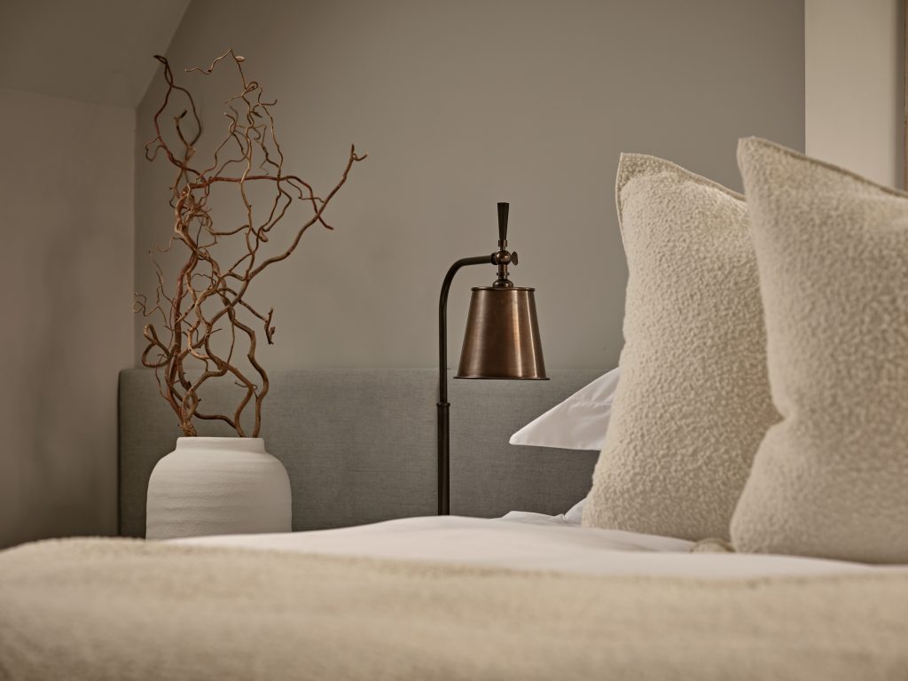 Layered, neutral bedroom scheme with natural textures and restrained detailing, illustrating how considered simplicity helps create a timeless home.