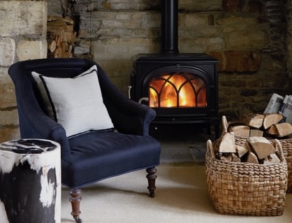 Winter interior design trends featuring a cosy living room with fireplace, textured furnishings and warm lighting
