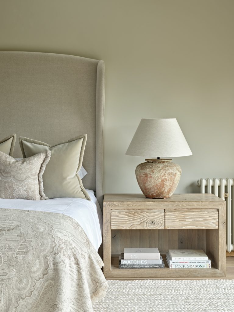 Bedroom interior within a converted Cotswolds barn featuring layered textures and calm, neutral finishes