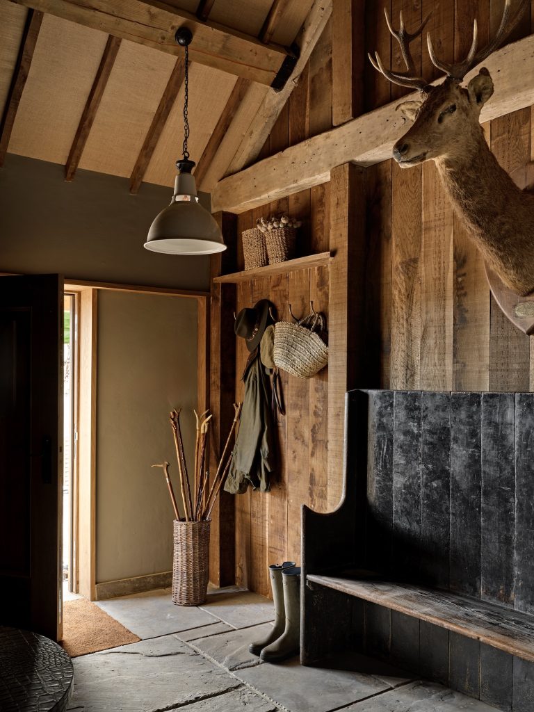 Boot room interior in a Cotswolds country residence featuring oak-clad walls and bespoke joinery